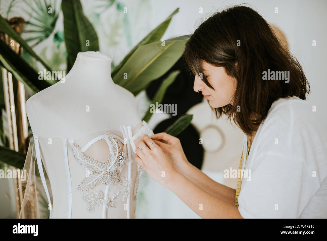 Jeune créateur de mode de faire une robe de mariage Banque D'Images