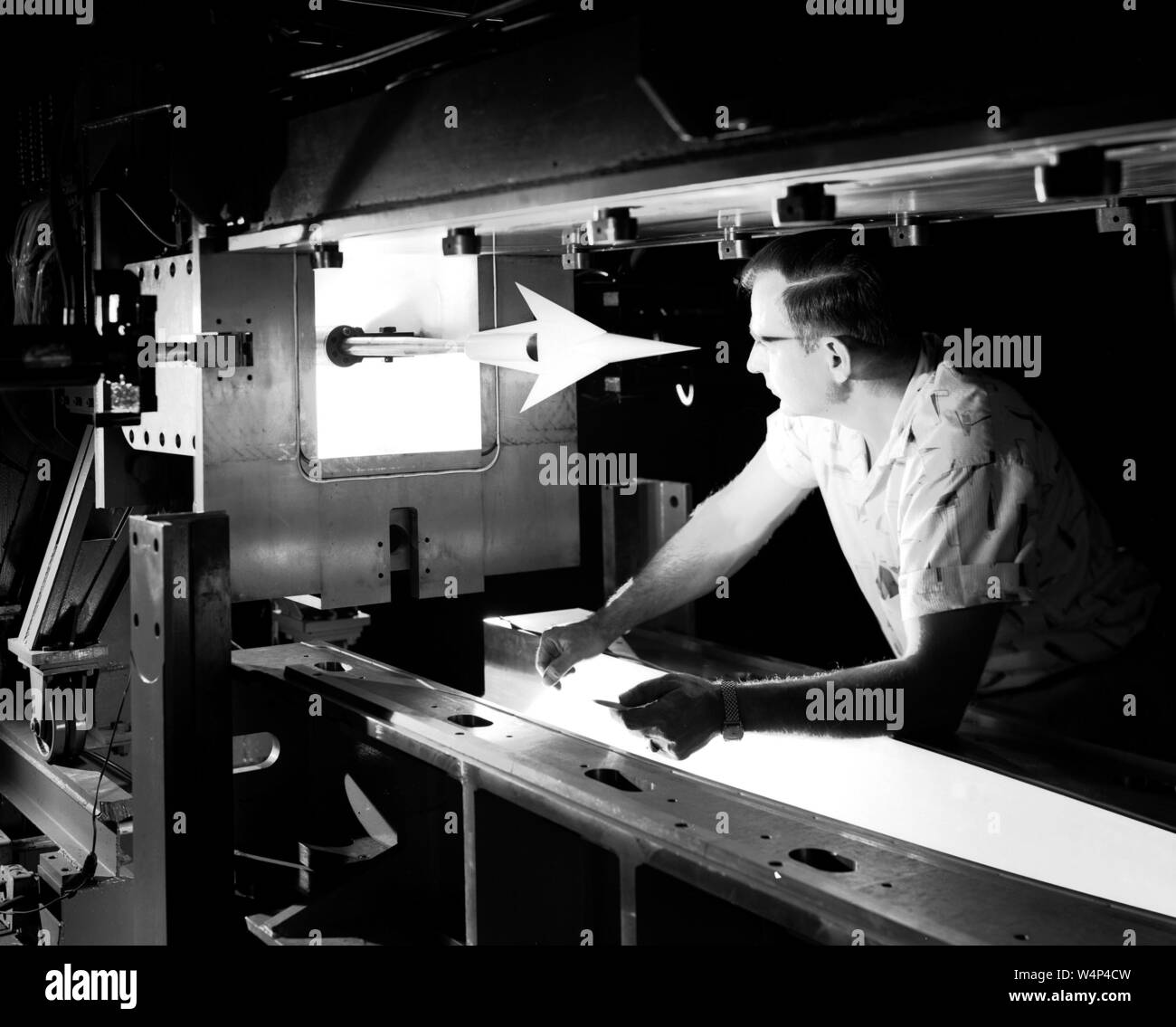Technicien de la NASA inspecte un modèle monté dans le 1x1 pieds Soufflerie supersonique au Glenn Research Center, Cleveland, Ohio, le 11 septembre 1957. Droit avec la permission de la National Aeronautics and Space Administration (NASA). () Banque D'Images