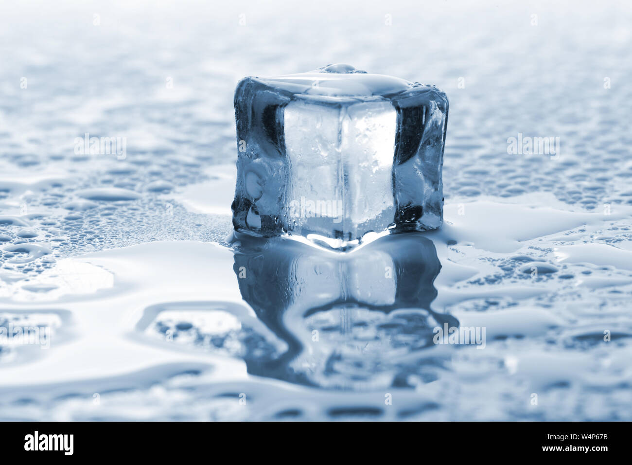 Un cube de glace unique de fusion avec ton bleu Banque D'Images