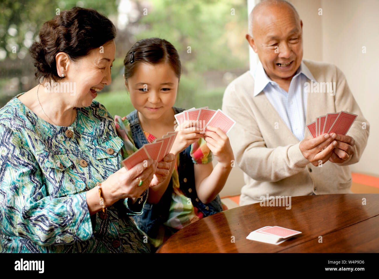 Couple de cartes à jouer avec leur petite-fille. Banque D'Images