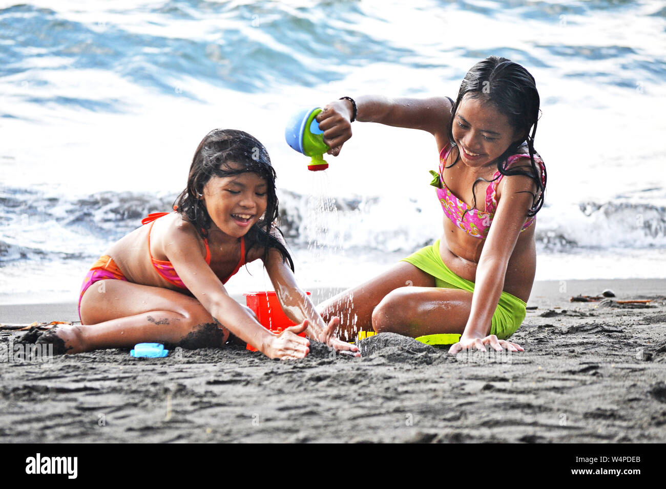 De belles jeunes filles asiatiques s'amusant avec des jouets sur une plage tropicale Banque D'Images