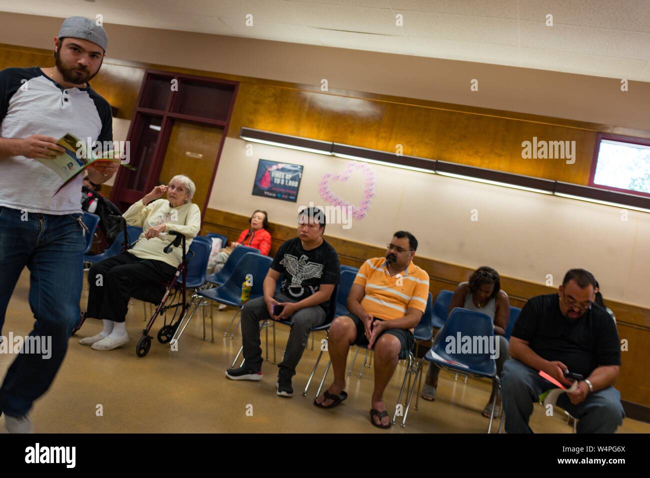 Les gens attendent dans des chaises pour leurs numéros à appeler, l'examen des manuels du conducteur, au California Department of Motor Vehicles (DMV) à Pleasanton, Californie, le 28 août 2018. () Banque D'Images