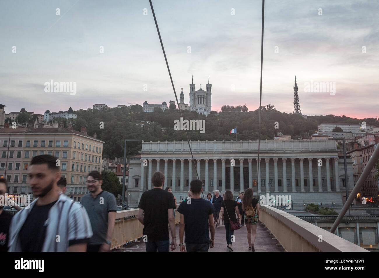 LYON, FRANCE - 17 juillet 2019 : Les gens qui passent sur un pont en face de la Colline de la colline de Fourvière avec sa basilique emblématique et la Cour de Justice, un Banque D'Images