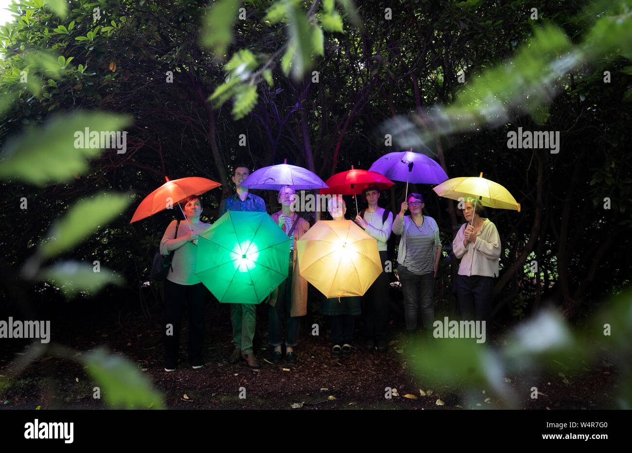 Les visiteurs franchissent le Royal Botanic Garden Edinburgh au crépuscule avec des parasols lumineux "Sonic", qui jouent le chant de Caithness et Sutherland. La pièce est l'un des plusieurs installations créés par des artistes de tout le Royaume-Uni, qui ont été chargés de produire une série de nouveaux visuels, sonores et sensoriels installations cinétiques pour le dessous de la couverture de l'événement d'art dans le cadre de l'Edinburgh Festival Fringe 2019. Banque D'Images