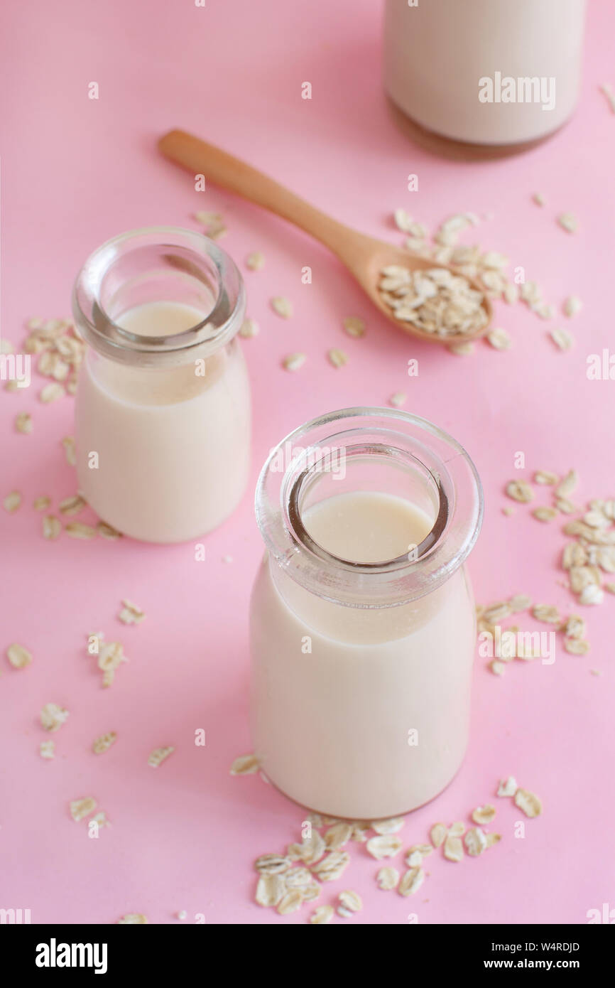 Le lait d'avoine végétalien, non dairy lait de substitution sur un fond rose clair Banque D'Images