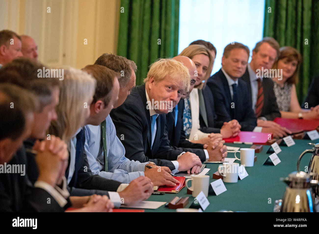 (De gauche à droite, assis à table) Secrétaire de l'éducation Gavin Williamson, Commerce international, Secrétaire Liz Truss Secrétaire de soins de santé et sociaux Matt Hancock, secrétaire du Cabinet Sir Mark Sedwill, Premier ministre Boris Johnson, chancelier de l'Échiquier Sajid Javid, Travaux publics et des retraites et Ministre pour les femmes, le logement, l'Ambre Rudd, communautés locales et secrétaire Robert Jenrick, Secrétaire aux transports Grant Shapps, Secrétaire écossais Alister Jack et Morgan, Nicky Secrétaire de la culture en tant que premier ministre Boris Johnson tient sa première réunion du Cabinet à Downing Street à Londres. Banque D'Images