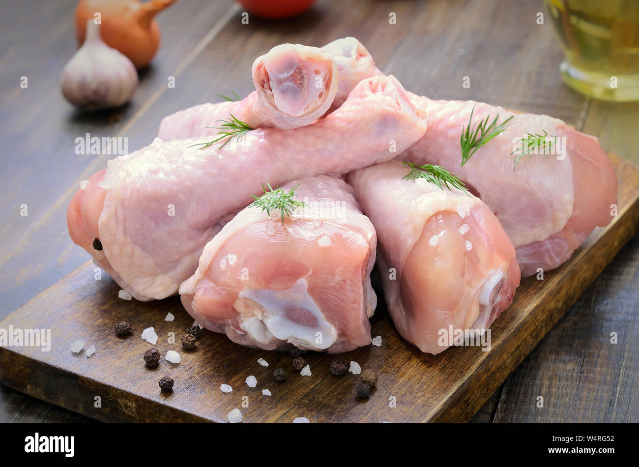 Pilons De Poulet Cru Et Epices Sur Planche A Decouper En Bois