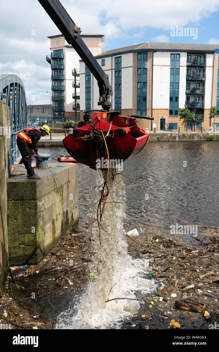 Nettoyage des débris recueillis au pont sur l'eau de rivière à Leith Leith après de fortes pluies, Ecosse, Royaume-Uni Banque D'Images