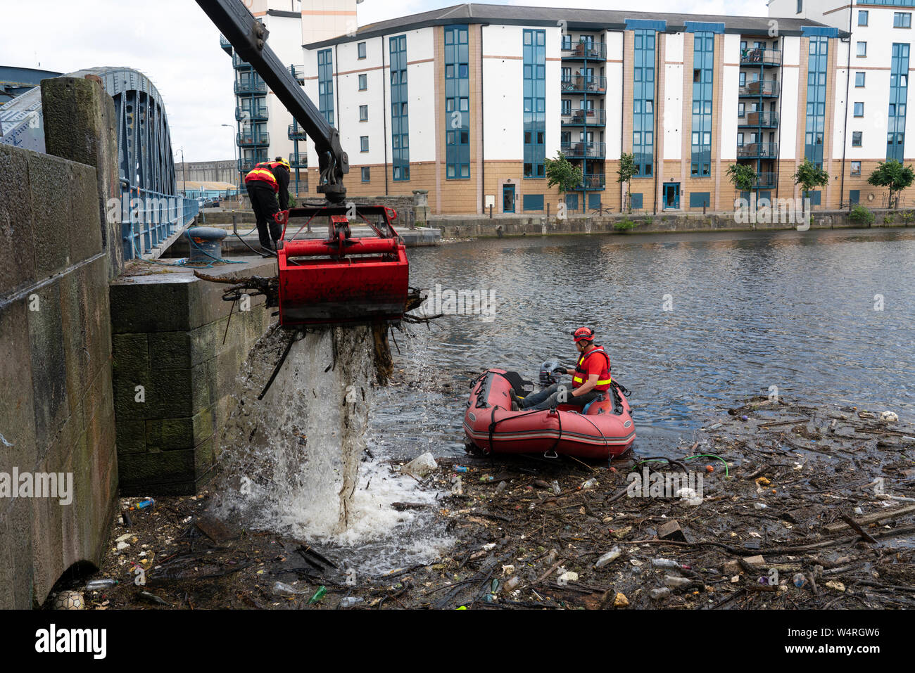 Nettoyage des débris recueillis au pont sur l'eau de rivière à Leith Leith après de fortes pluies, Ecosse, Royaume-Uni Banque D'Images