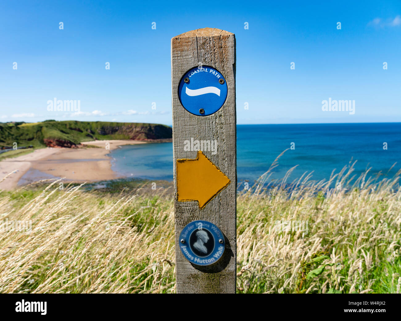 Le marqueur ou James Hutton à pied sur chemin côtier à Pease Bay dans le Berwickshire, Ecosse, Royaume-Uni Banque D'Images