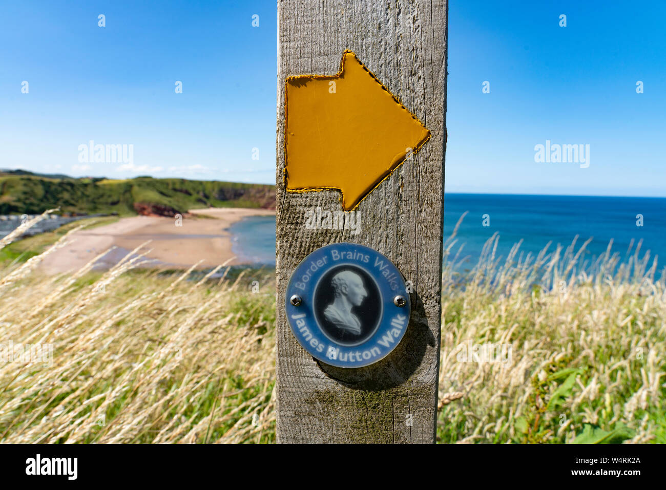 Le marqueur ou James Hutton à pied sur chemin côtier à Pease Bay dans le Berwickshire, Ecosse, Royaume-Uni Banque D'Images