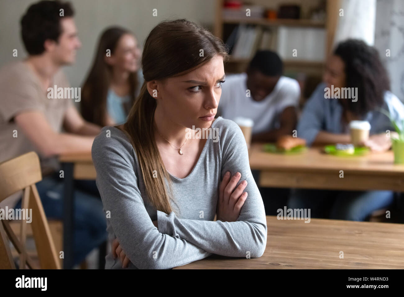 Contrarié offensé par amis jeune femme assise seule. Banque D'Images