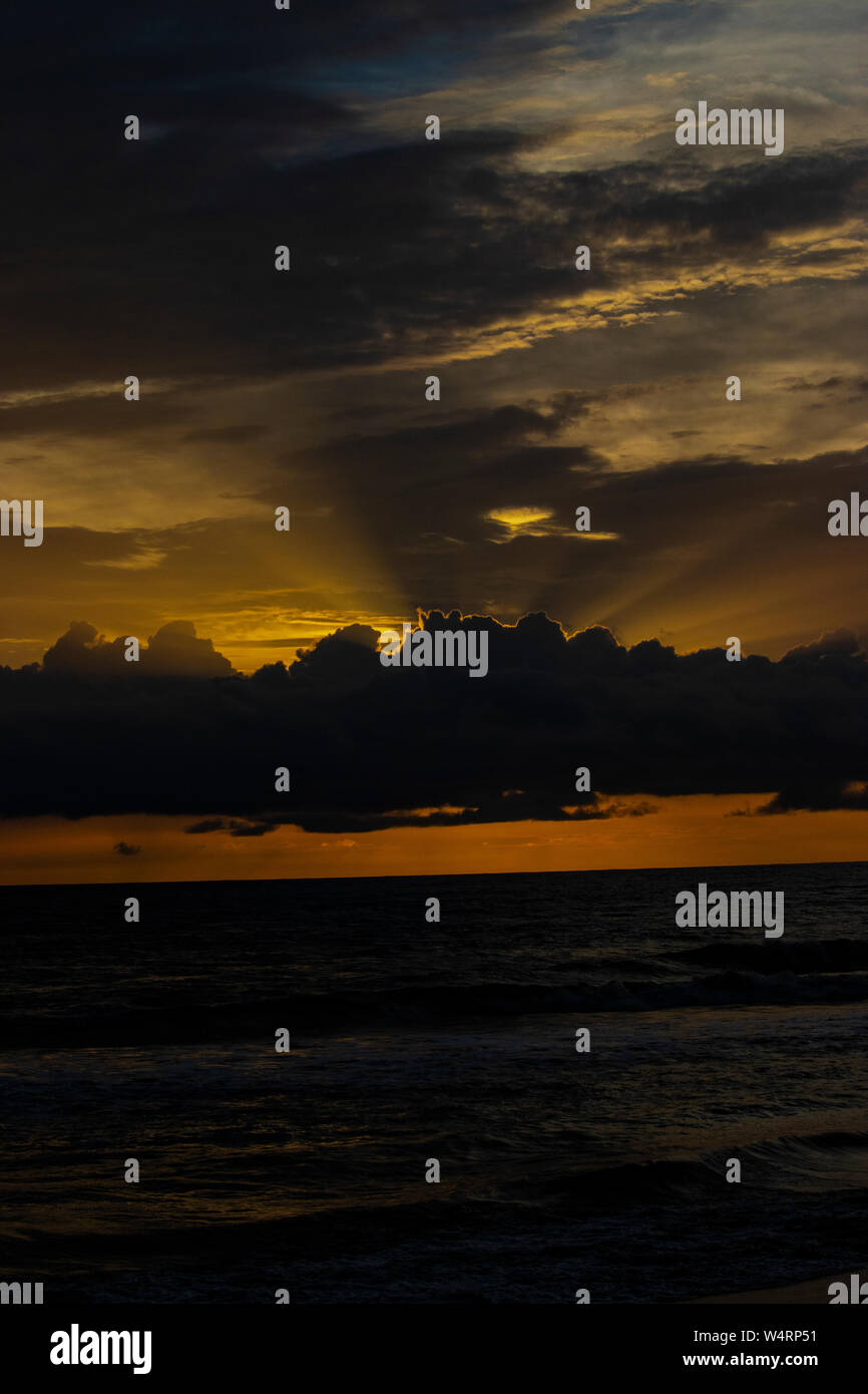 Ciel Orange avec rayons de soleil venant de l'arrière du nuage au-dessus de la mer Banque D'Images