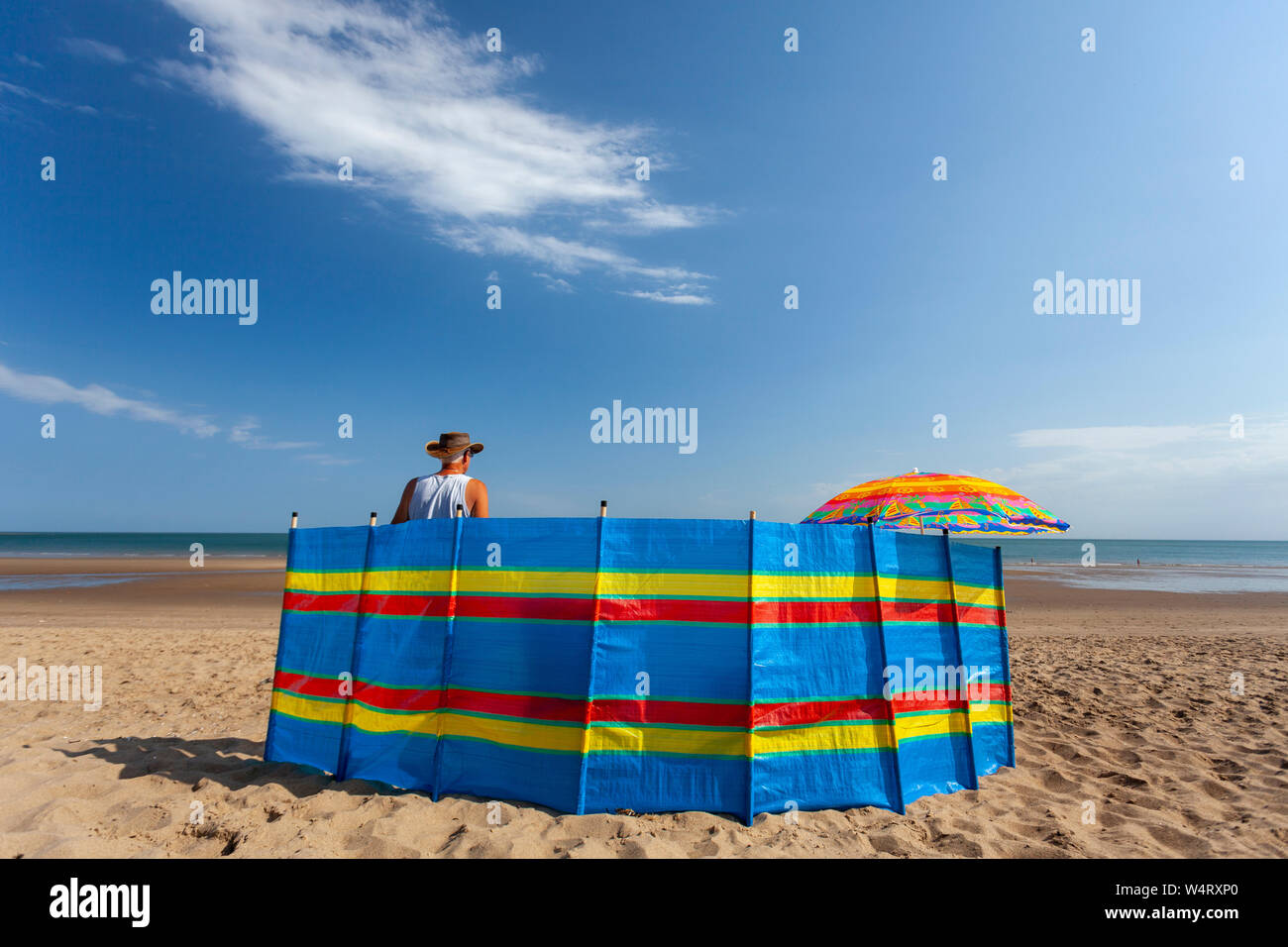 Le Nord du Pays de Galles, Royaume-Uni. Le 25 juillet, 2019. UK : Météo Météo canicule pourrait casser UK Tous les relevés de temps aujourd'hui pour certaines régions du Royaume-Uni, les températures devraient atteindre les 39C pour le sud-est avec de nombreuses parties au-dessus de 30°C. Le littoral du nord du Pays de Galles, baigné de lumière du soleil chaude comme la canicule atteint son maximum aujourd'hui comme un visiteur de plage donne sur la mer de son ombre sur l'écran d'Cowlyn Bay Beach, au nord du Pays de Galles. Credit : DGDImages/Alamy Live News Banque D'Images
