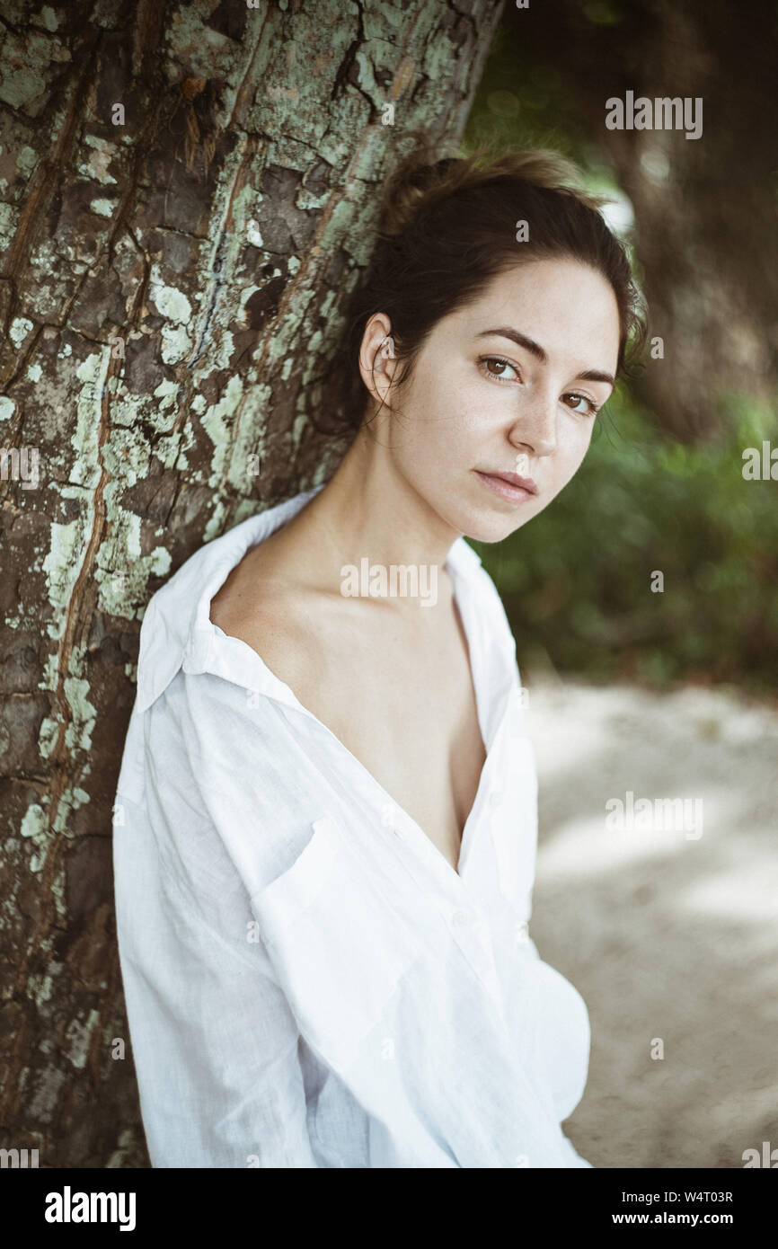 Portrait d'une femme appuyée contre un arbre, les Seychelles Banque D'Images