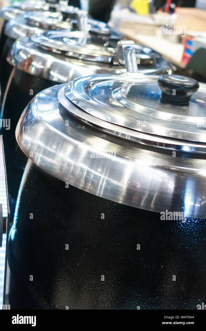 Grand professionnel dans des pots en acier d'une ligne dans une cuisine de restaurant à la market food court Banque D'Images