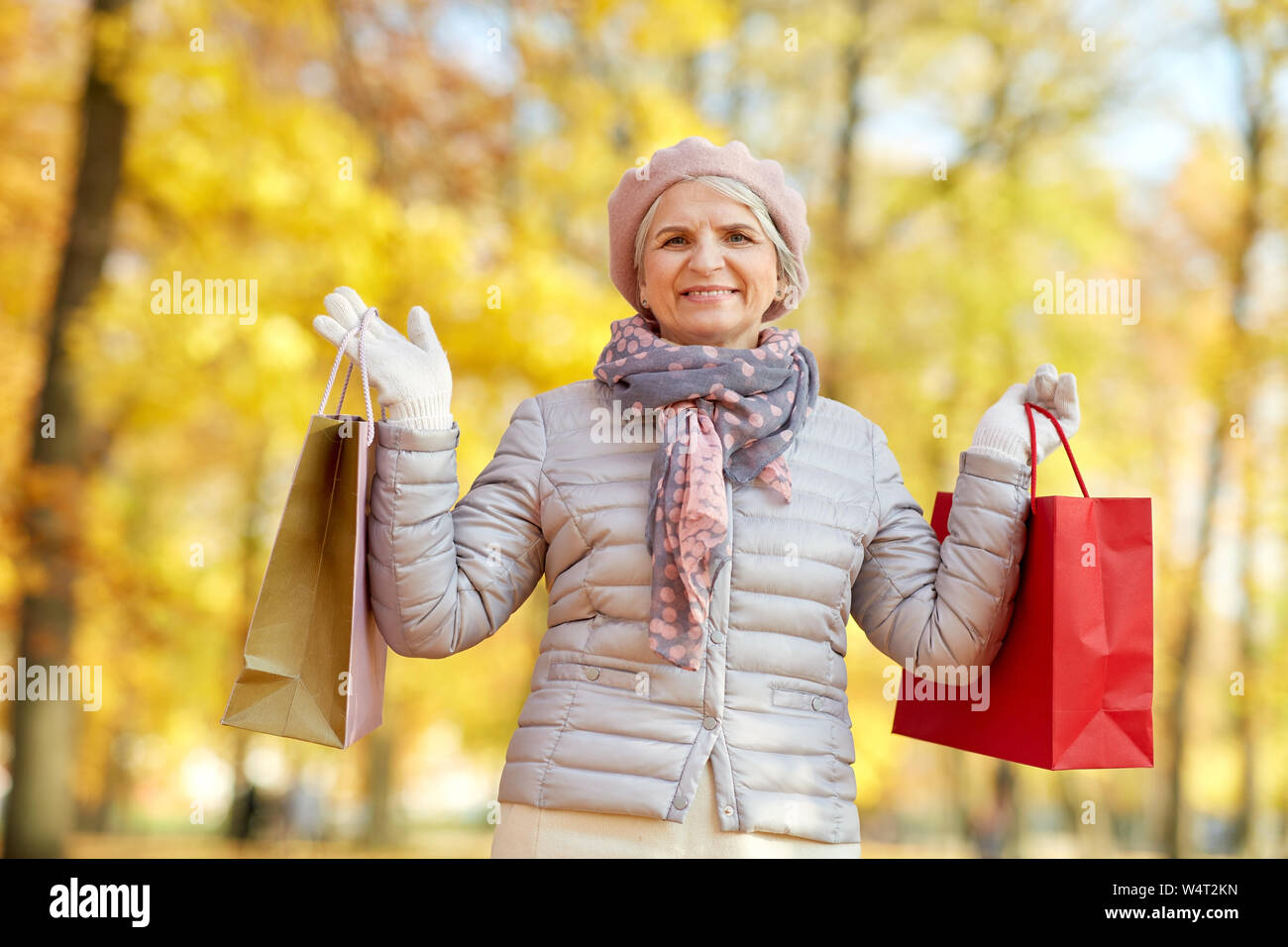 Senior woman with shopping bags at autumn park Banque D'Images