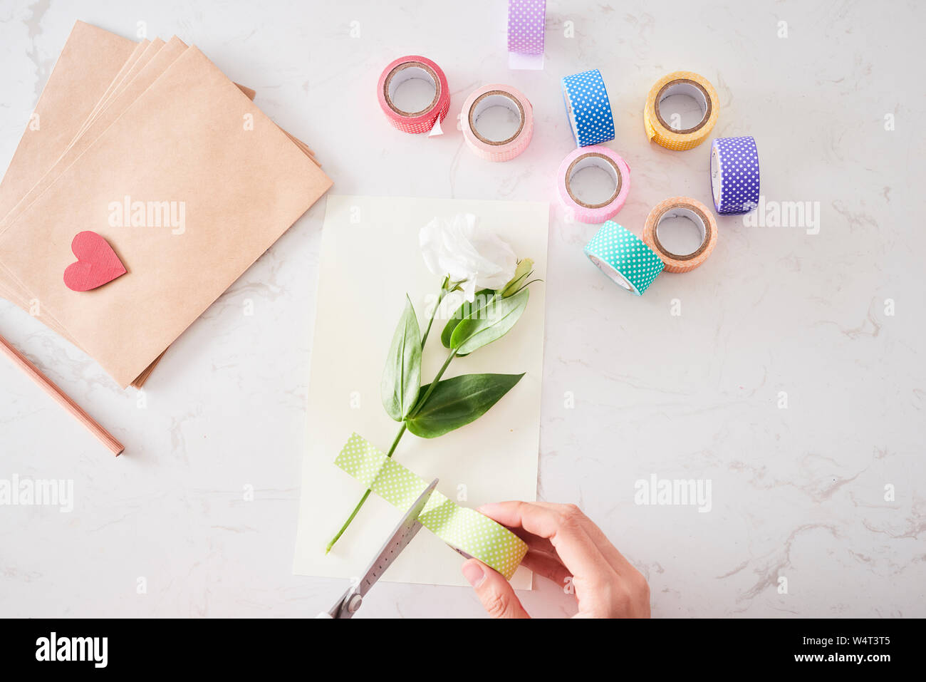 Faire des décorations ou des cartes de vœux. Les bandes de papier, fleur, des ciseaux. De l'artisanat en vacances : Anniversaire, fête des Mères ou la Fête des Pères, le 8 mars, mariage. Banque D'Images