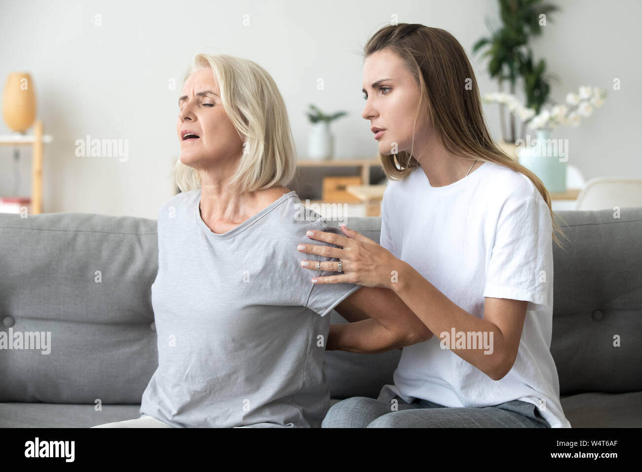 Mère souffrant de maux de dos fille retrouvez sentiment Banque D'Images