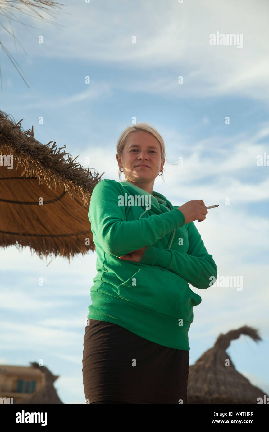 Femme avec cigarette sur la plage Banque D'Images