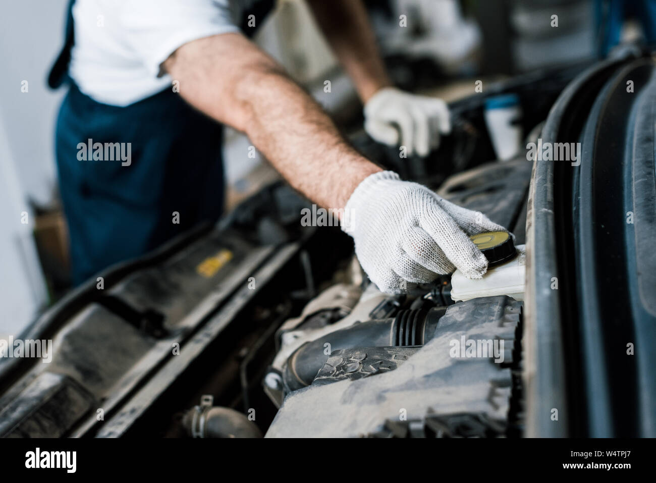 Portrait de mécanicien de voiture de toucher une capsule de bouteille dans l'automobile Banque D'Images