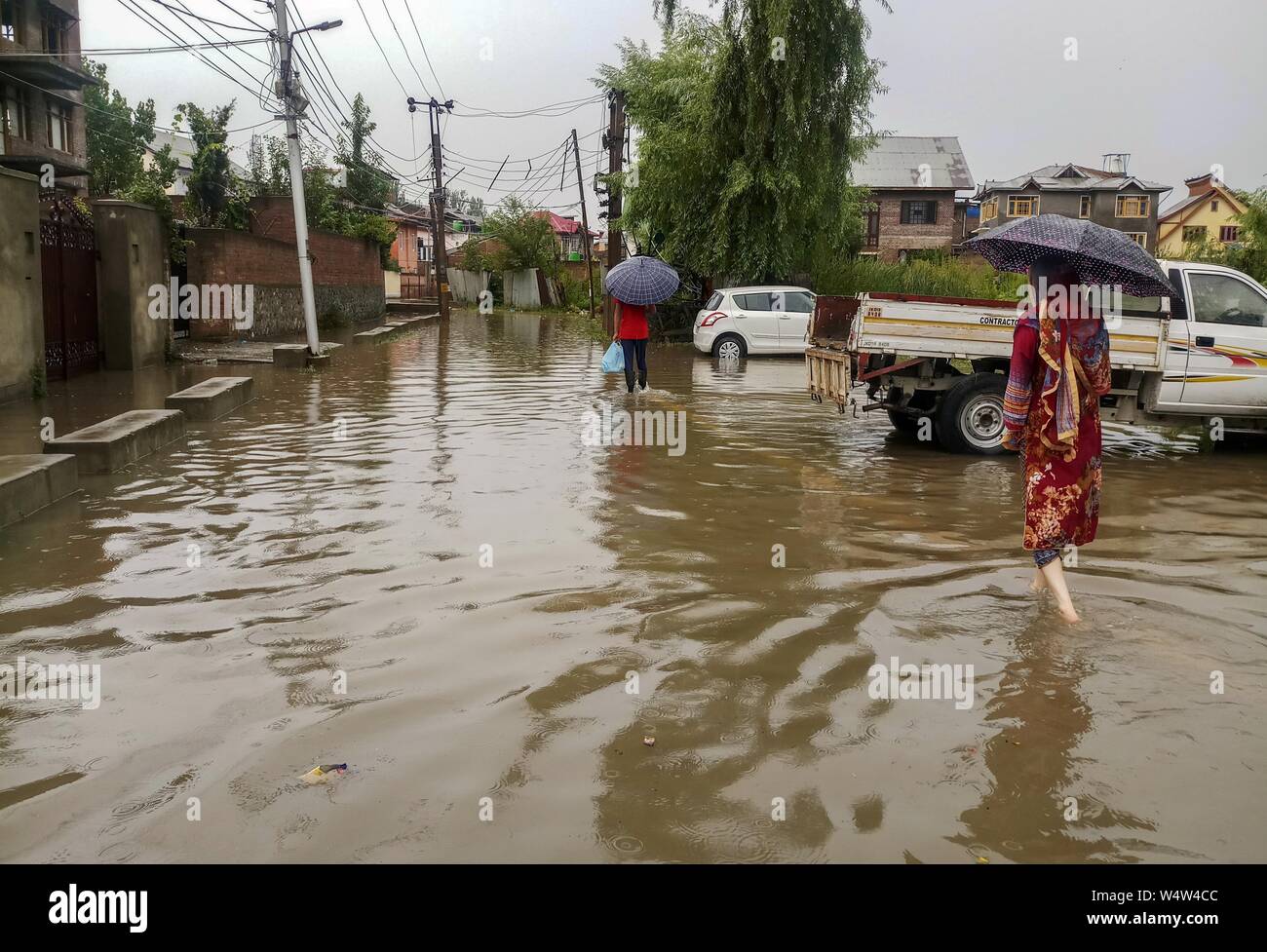 Srinagar, Inde. Le 25 juillet, 2019. Au cours de la wade résidents de fortes pluies dans la région de Srinagar.De fortes pluies ont provoqué l'engorgement dans de nombreux domaines de Srinagar exposant le mauvais drainage de la ville. Le temps le ministère a prévu plus de précipitations dans de nombreuses régions de la vallée dans les prochaines 24 heures. Credit : SOPA/Alamy Images Limited Live News Banque D'Images