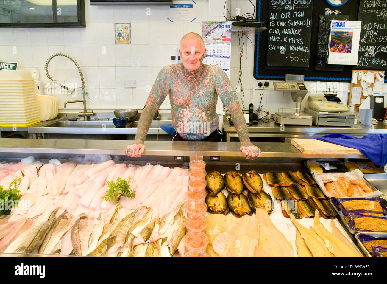 Homme tatoué travaillant dans des poissonniers Banque D'Images