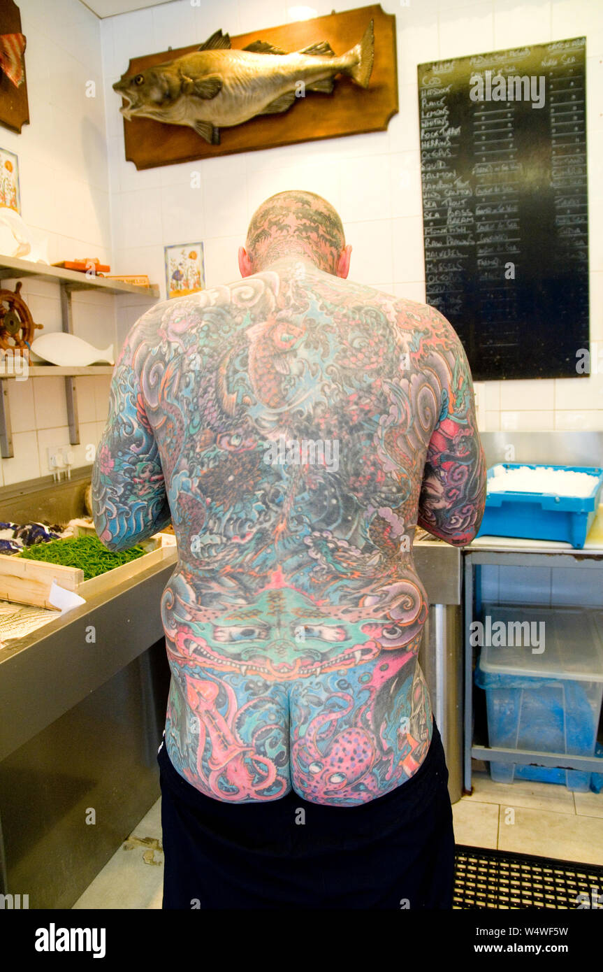 Homme tatoué travaillant dans des poissonniers Banque D'Images