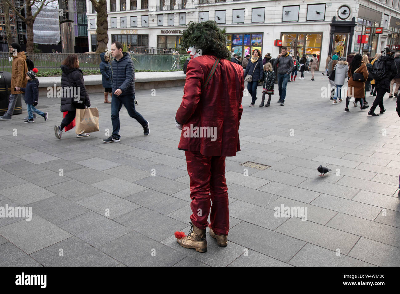 L'homme habillé en Joker caractère type aux dents pourries, tiges autour sur Leicester Square en essayant de faire peur aux passants à Londres, Royaume-Uni. Banque D'Images