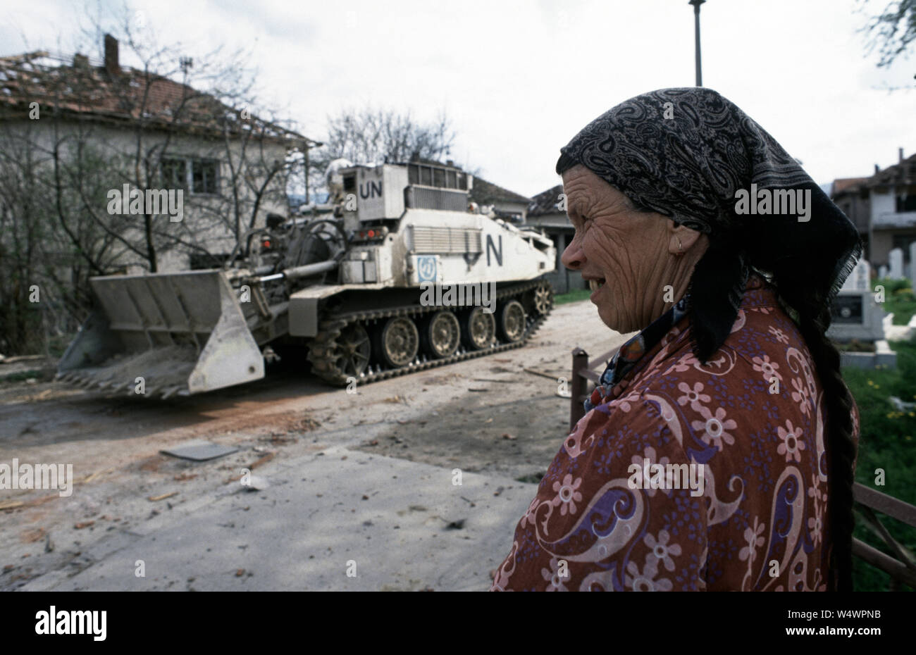 25 avril 1993 pendant la guerre en Bosnie : dans le centre de Stari Vitez, une vieille femme regarde l'opération pour récupérer les corps après un gros camion bombe a détruit la présidence de guerre en Bosnie. Dans l'arrière-plan est une armée britannique FV180 Combat Engineer tracteur (TEC) de la Cheshire Regiment. Banque D'Images