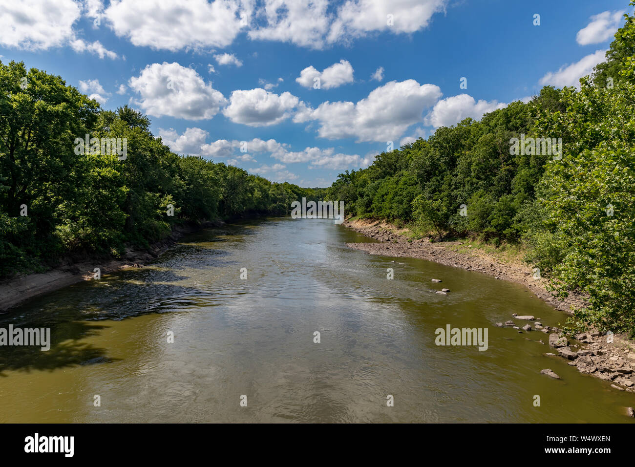 L'eau qui coulait le long des rives rocheuses de la Rivière Sangamon entourée d'arbres sur une journée ensoleillée avec des nuages Banque D'Images