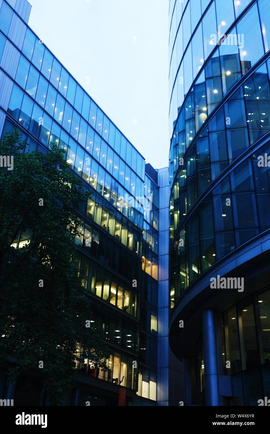 Un immeuble à Londres, UK dans une couleur bleuâtre et un grand nombre de fenêtres tourné en un faible angle de vue. La photo a été prise la nuit et un jour nuageux. Banque D'Images