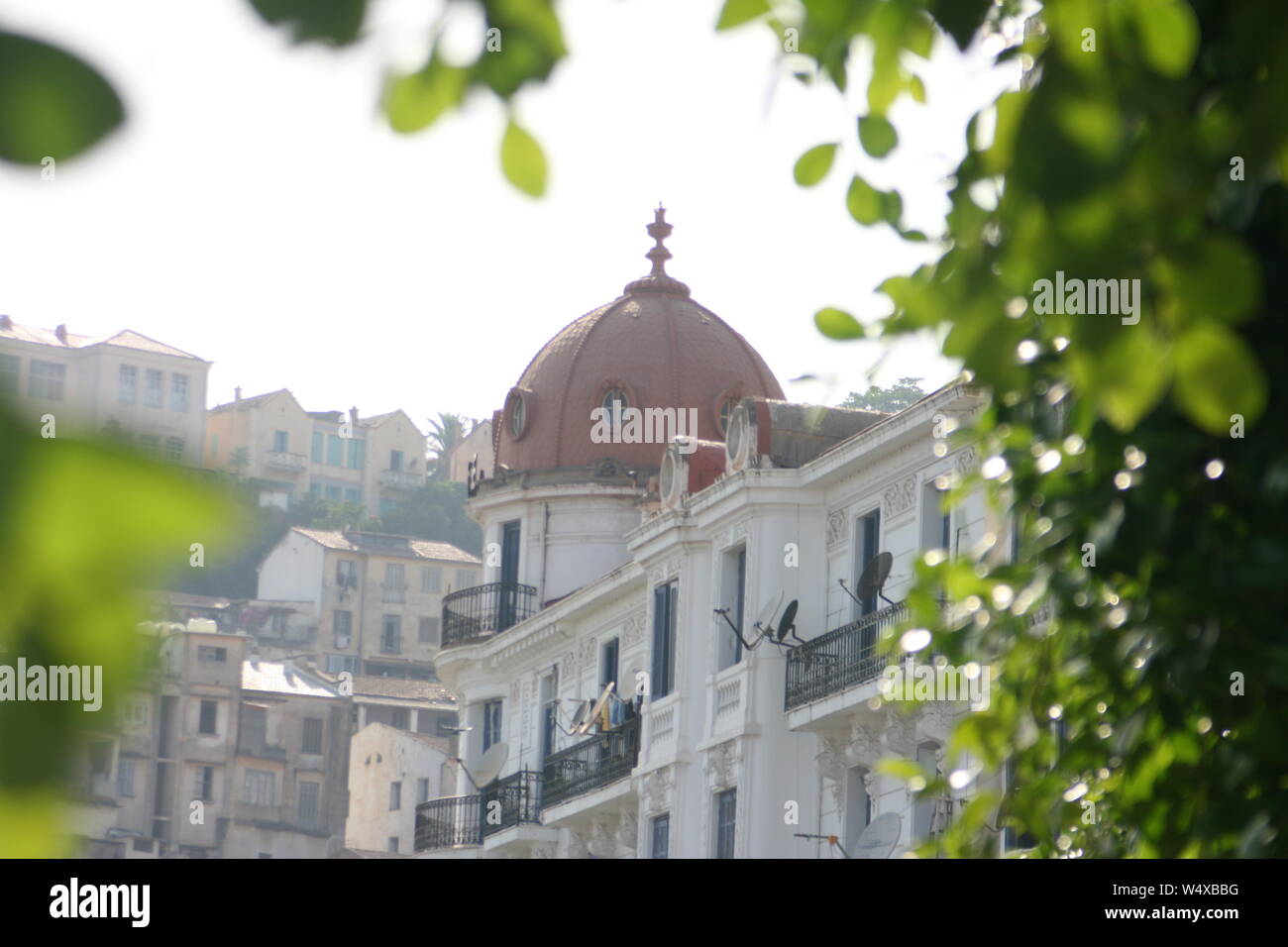Maison coloniale française avec un dôme, encerclé par les feuilles des arbres dans la région de Bejaia Algerie Banque D'Images