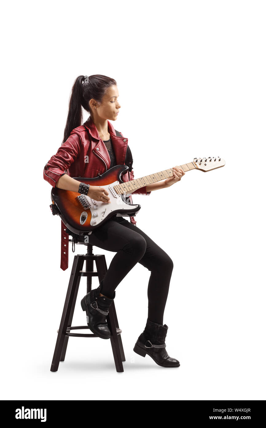 Tourné sur toute la longueur d'une jeune femme musicien assis sur une chaise et jouer la guitare électrique isolé sur fond blanc Banque D'Images