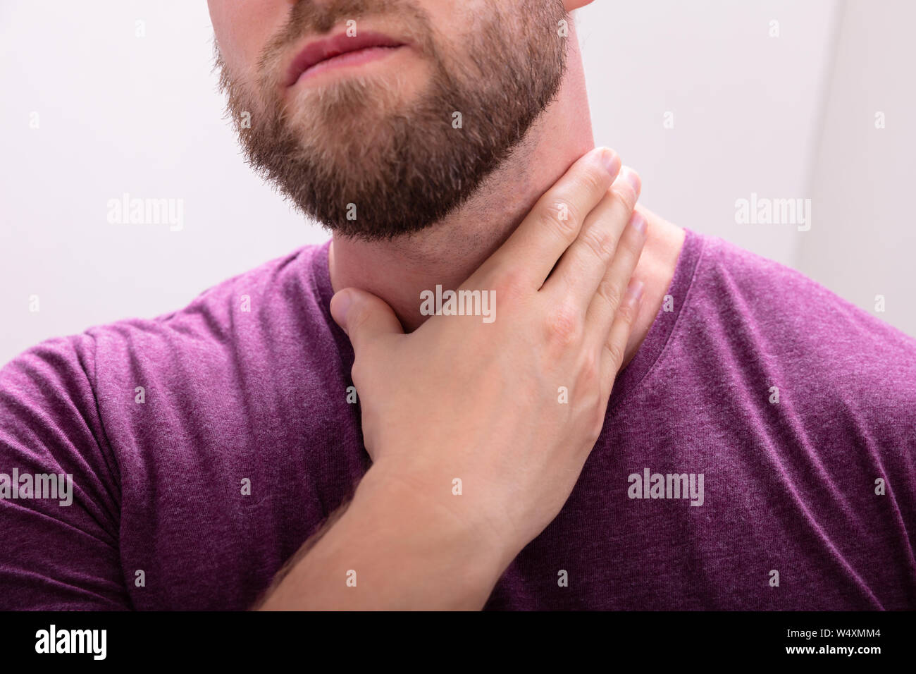 Portrait d'un homme à barbe touchant ses maux de gorge Banque D'Images