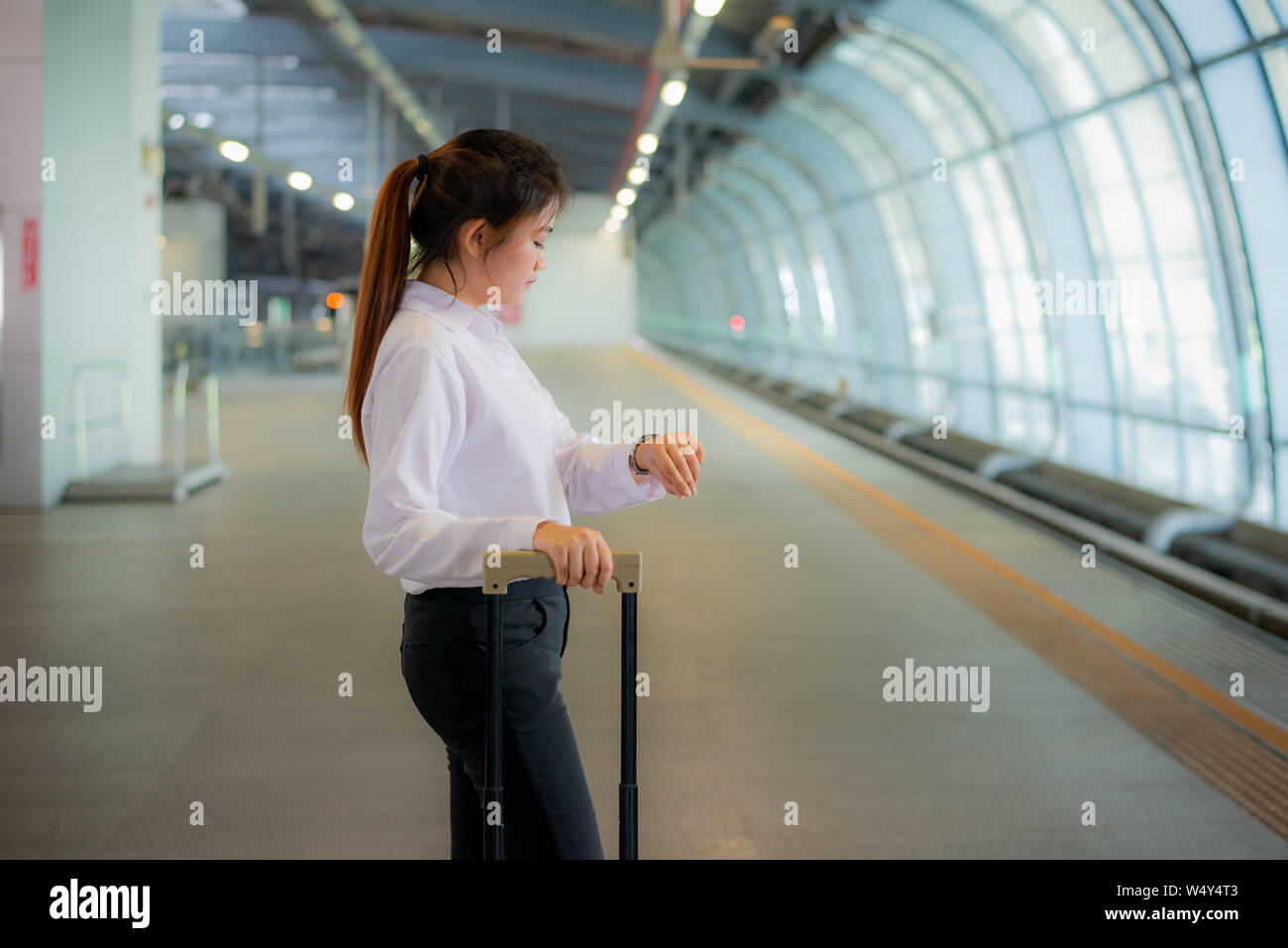 Beau young asian businesswoman traveler à Réveil de pair avec les bagages ,en attente de train à la gare, Voyages et vacances. Banque D'Images