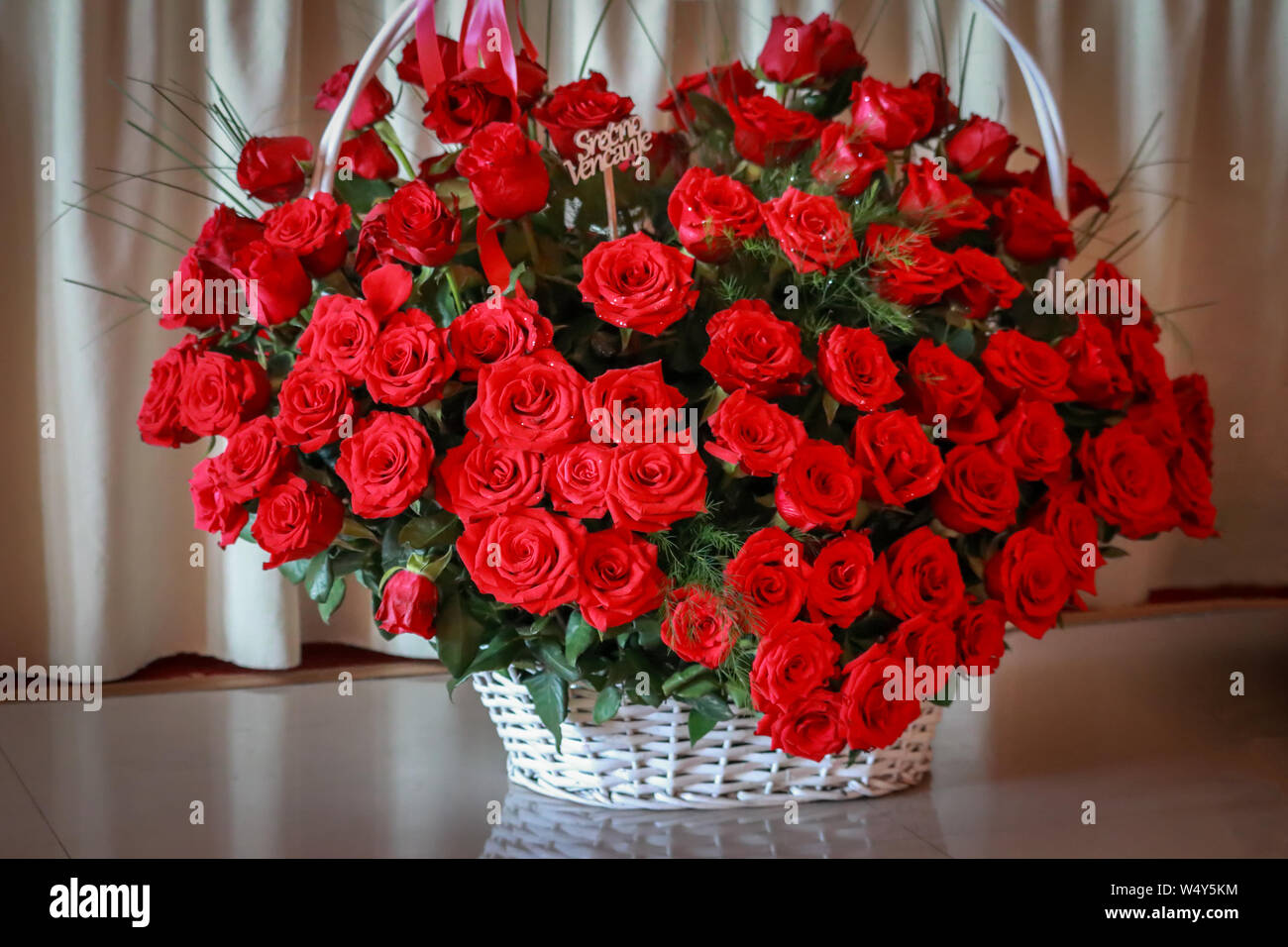 Gros bouquet de roses rouges dans le livre blanc panier de mimosa Photo  Stock - Alamy