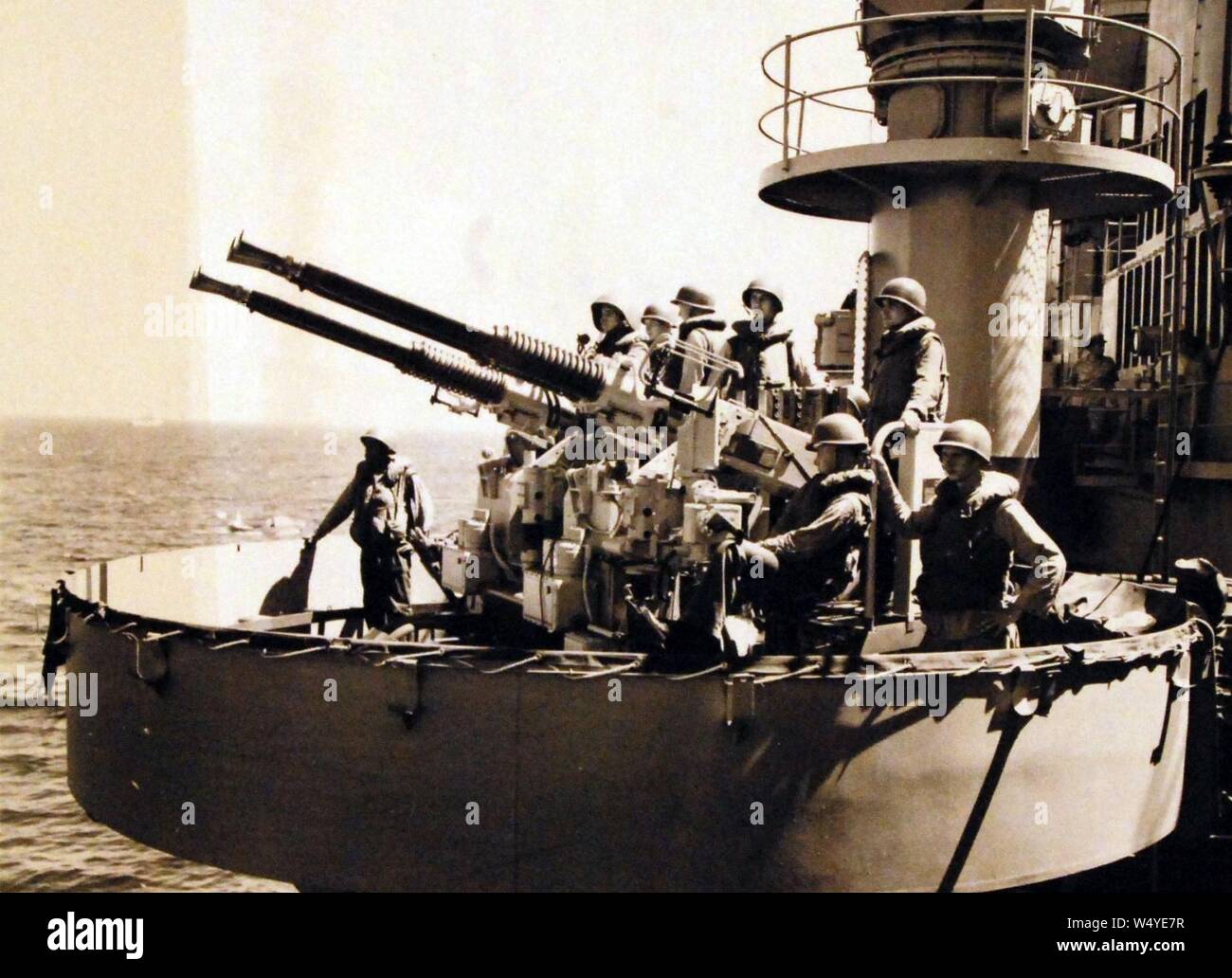 Les membres de l'équipage d'alerte permanent regarder sur un 40mm batterie anti-aérienne à bord du USS Rochester (CA 124), navire amiral de la septième flotte au cours des opérations en cours dans la région de Formosa. Banque D'Images