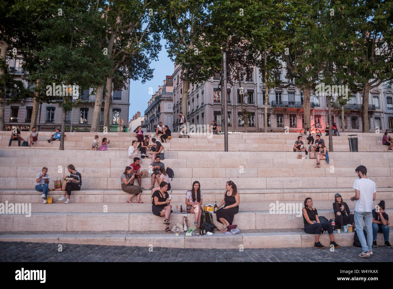 LYON, FRANCE - 18 juillet 2019 : les Français, principalement des femmes et des filles assis sur la rive du Rhône (quais) dans la soirée, tandis que les gens sont gath Banque D'Images