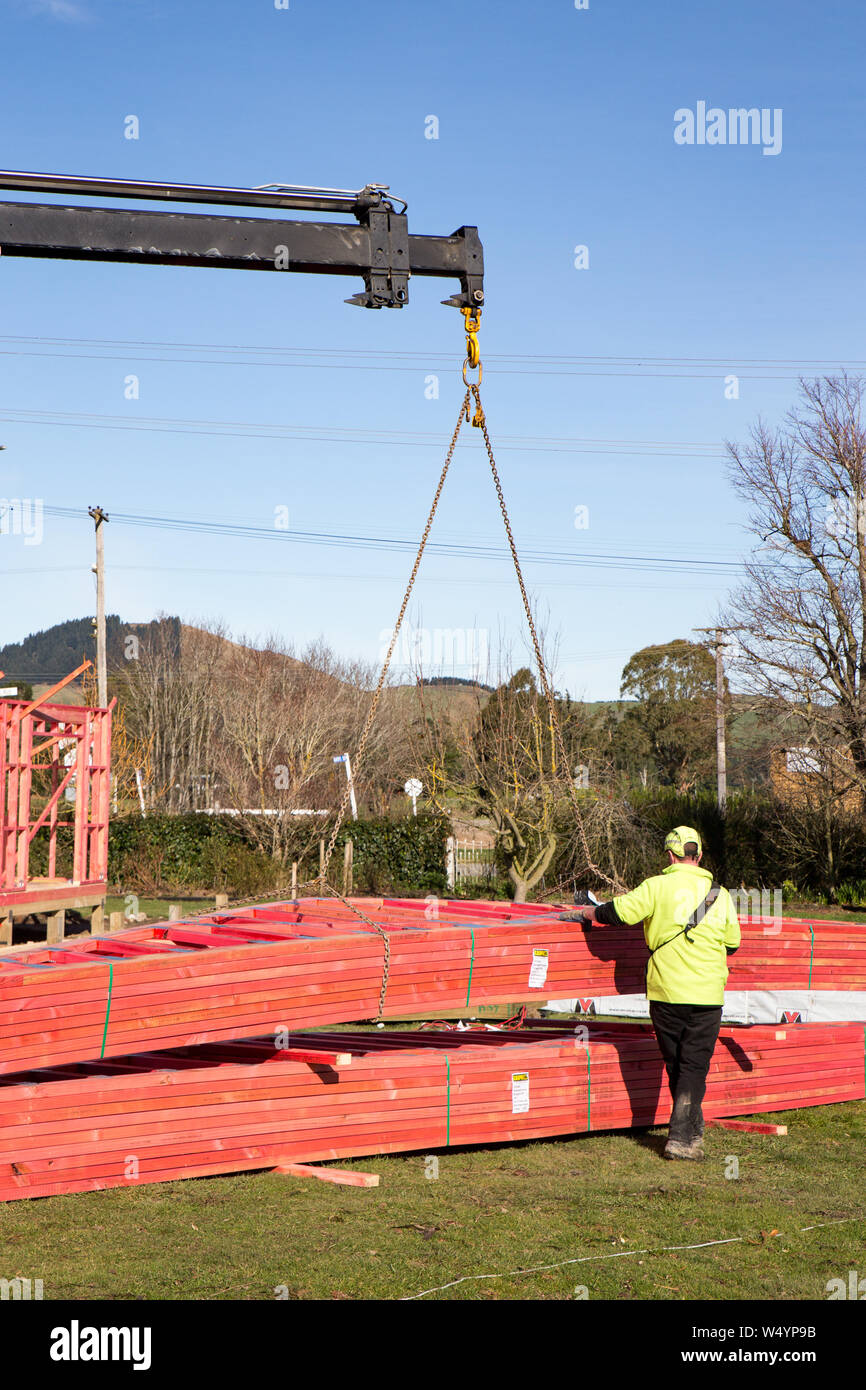 Sheffield. Canterbury, Nouvelle-Zélande, le 25 juillet 2019 : Builders décharger des fermes de toits qui ont été livré par un camion HIAB pour un chantier Banque D'Images