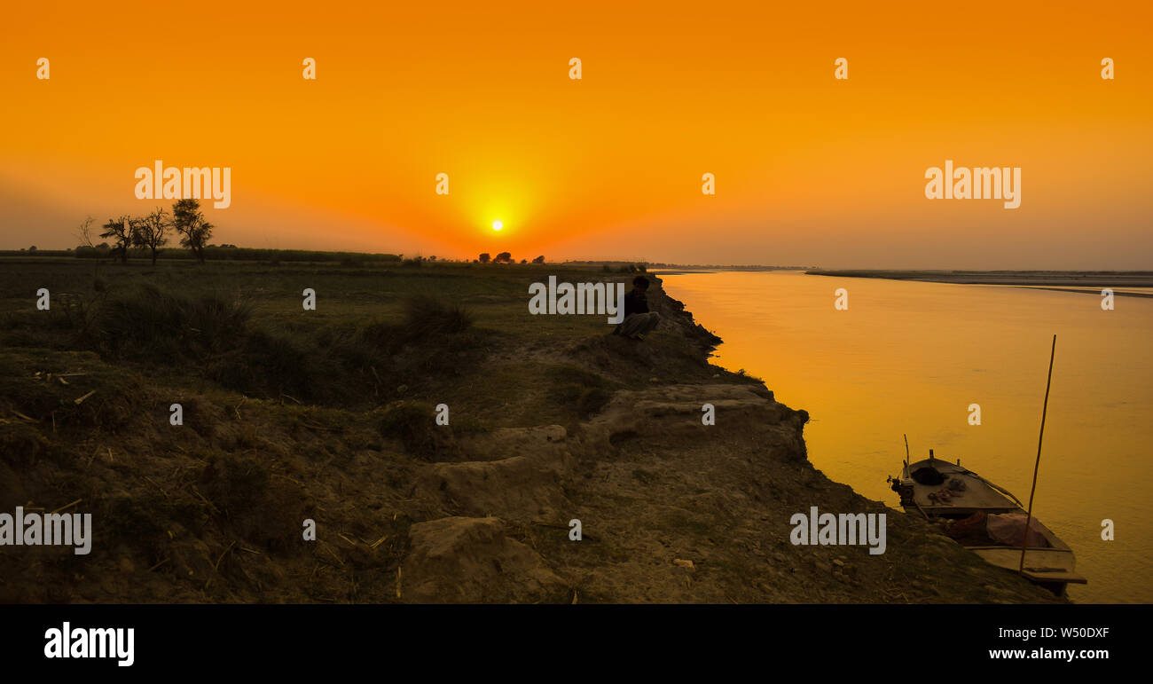 Un bateau sur une rive du fleuve à l'heure du coucher du soleil,une photo de paysage du fleuve Indus sunset punjab,le Pakistan. Banque D'Images