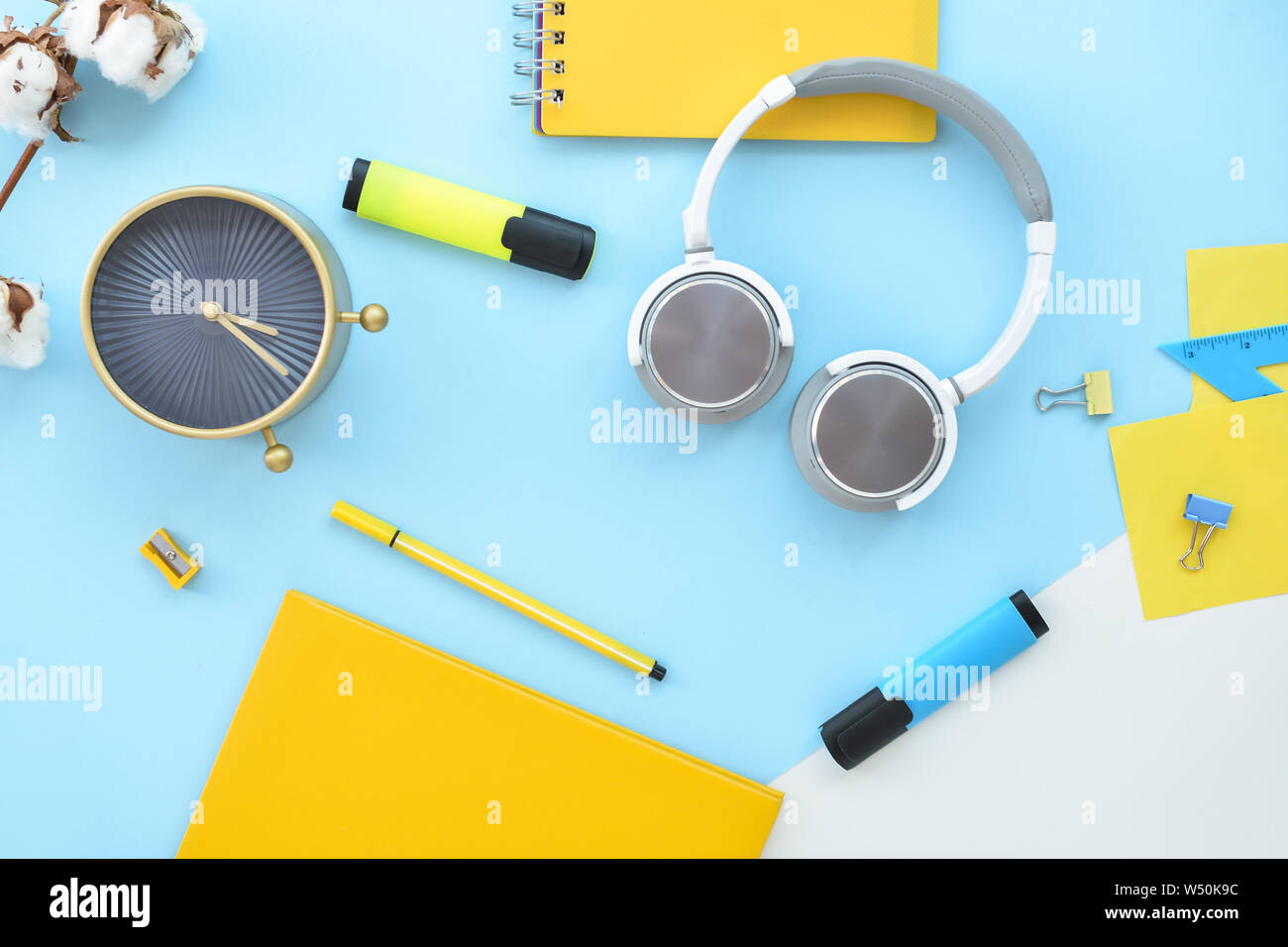 La composition avec la papeterie, réveil et d'écouteurs sur un fond de couleur Banque D'Images