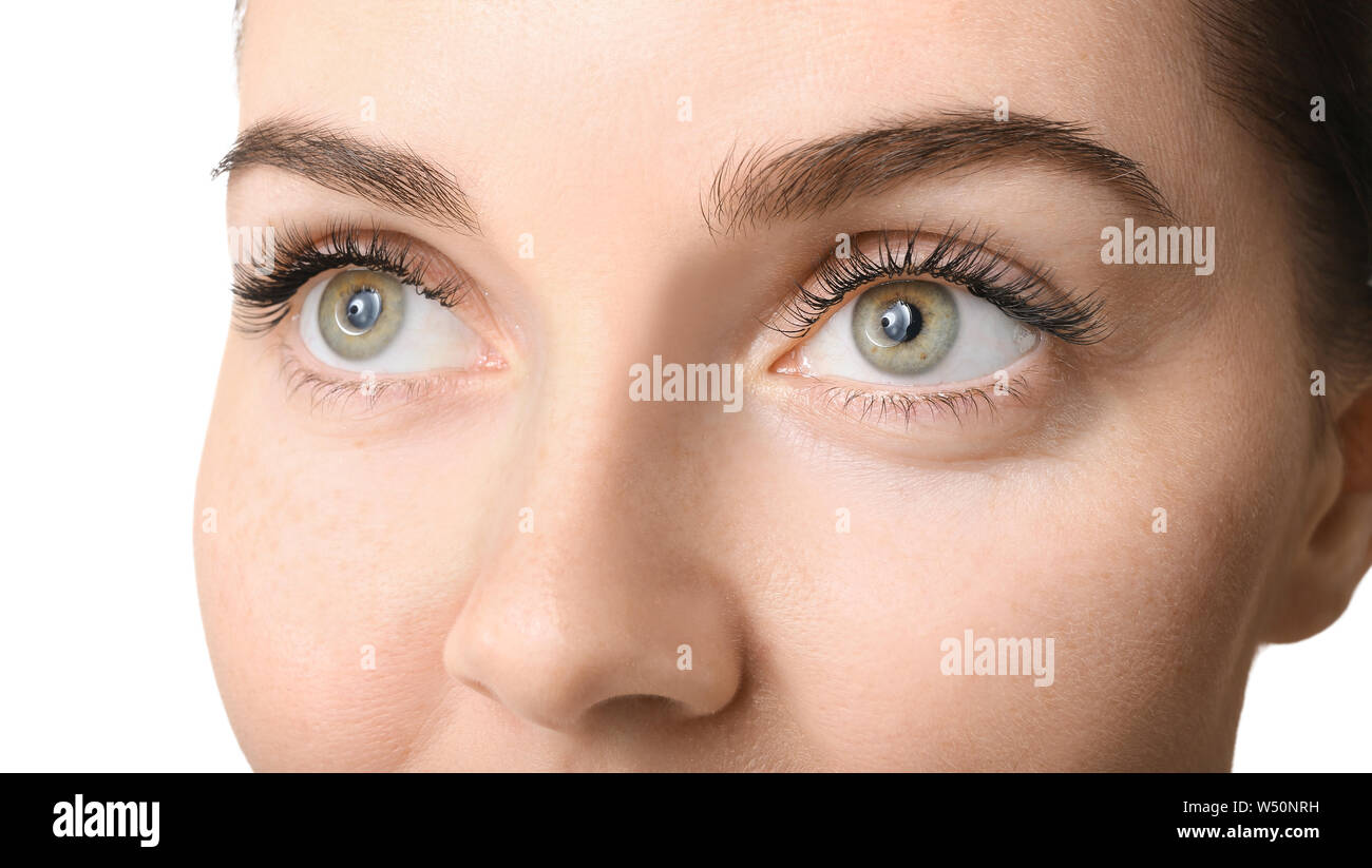 Belle jeune femme avec des extensions de cils sur fond blanc, gros plan Banque D'Images