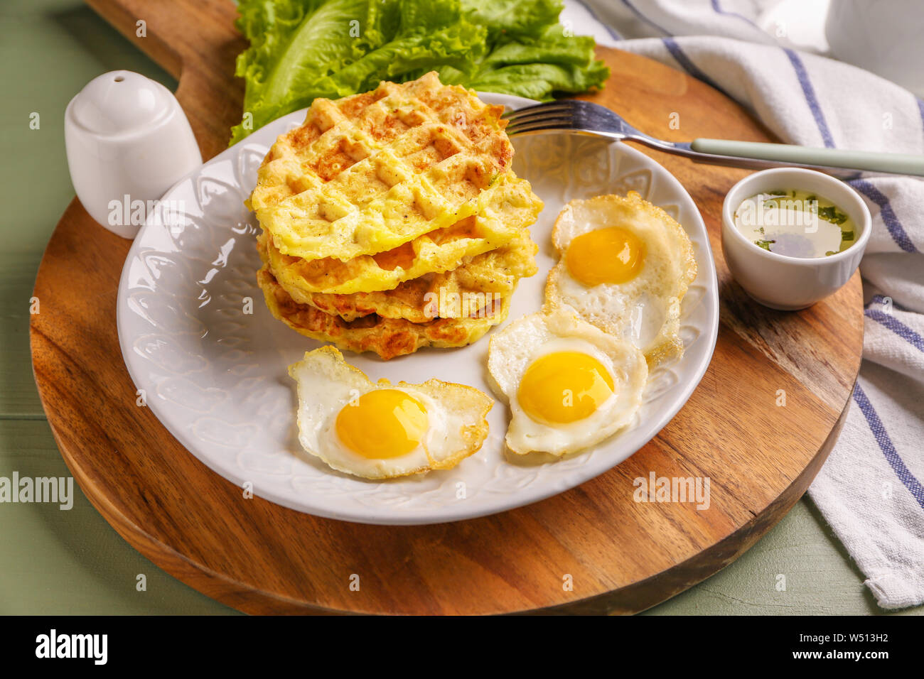 Plaque avec de délicieuses gaufres à la courge et les œufs de caille au plat sur table Banque D'Images