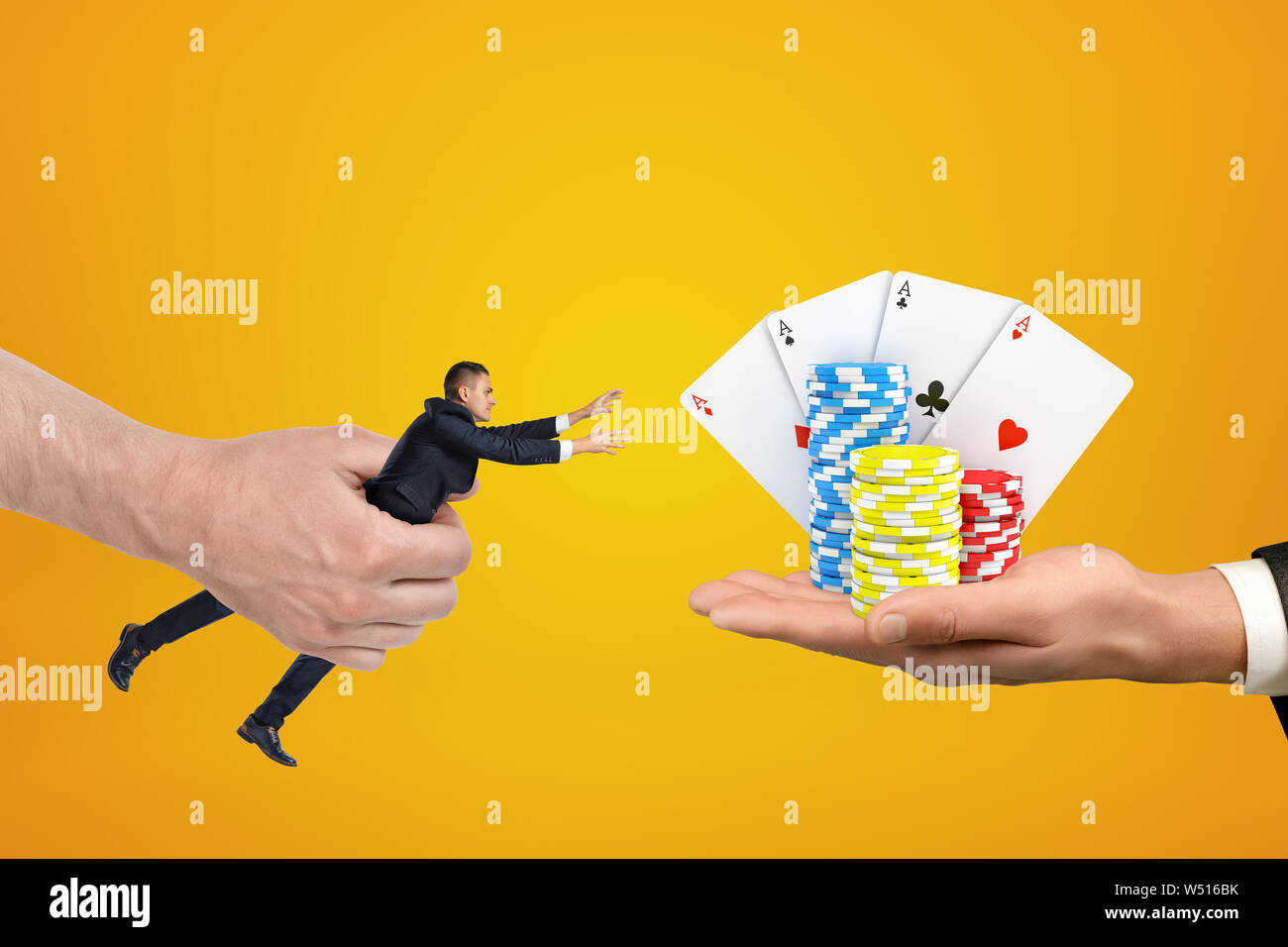 Man's hand holding tiny d'affaires qui tente d'atteindre avec les deux mains pour cartes et puces sur palm d'un autre homme sur fond orange. Banque D'Images