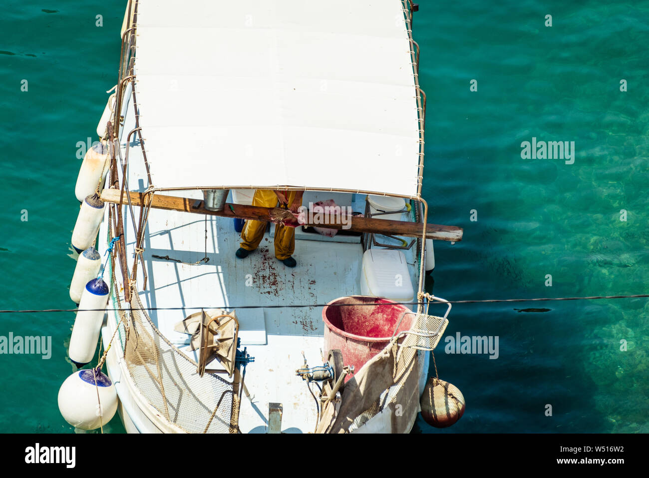 Le pêcheur travaillant sur bateau de pêche blanche et de poisson dans le port de la mer Méditerranée Banque D'Images