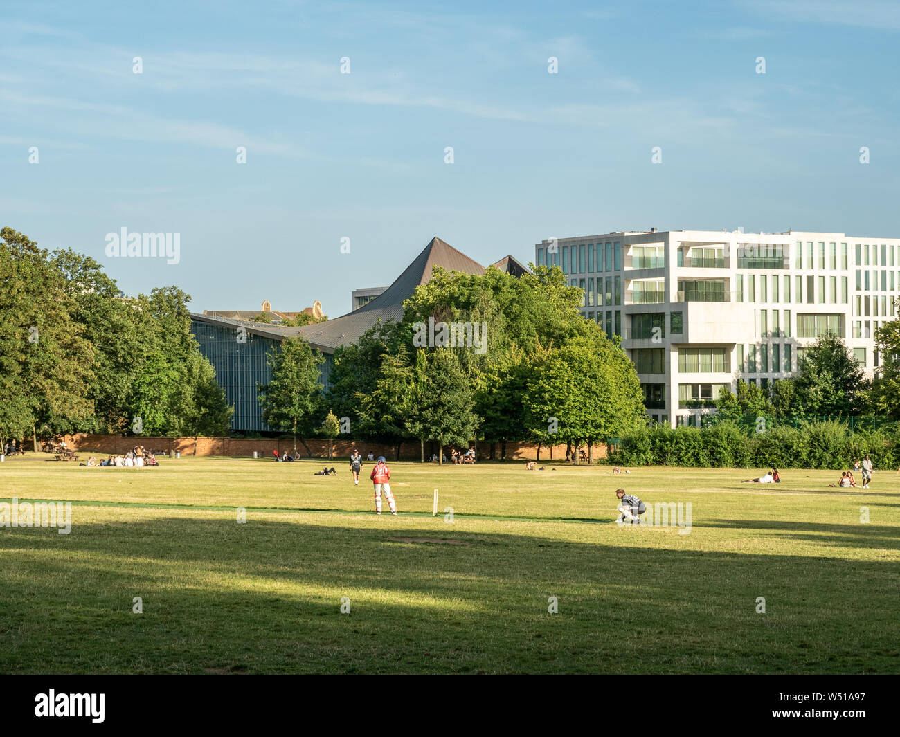 Cricket sur les terrains de jeu à côté de Holland Park, avec le Design Museum en arrière-plan, Londres. Banque D'Images