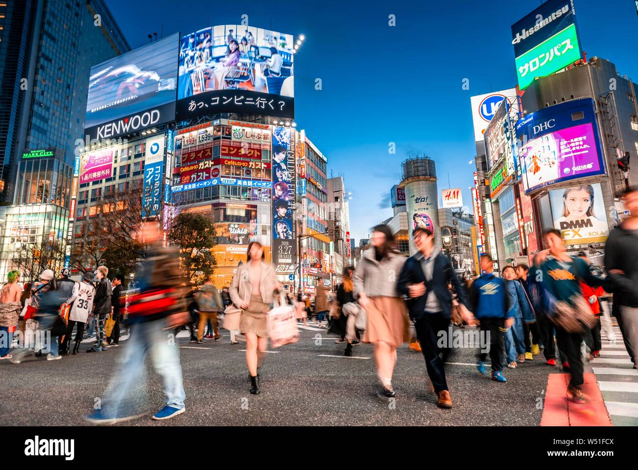 Croisement de Shibuya, une foule de gens à l'intersection, signes colorés et des enseignes au néon sur les gratte-ciel, crépuscule crépuscule, gare de Shibuya Banque D'Images