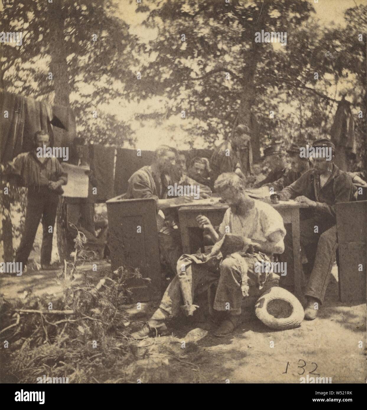 Groupe de soldats de la guerre civile au camp site, un homme assis, la couture sa chemise, pas de bouilloire, cuisine américaine, de 1862-1864, à l'albumine argentique Banque D'Images