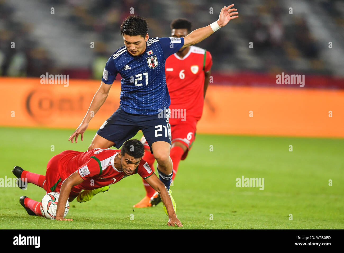 Ritsu Doan, droite, de l'équipe nationale de football du Japon passe le  ballon contre un joueur de l'équipe nationale de football d'Oman dans l'AFC Asian  Cup match du groupe F Photo Stock -